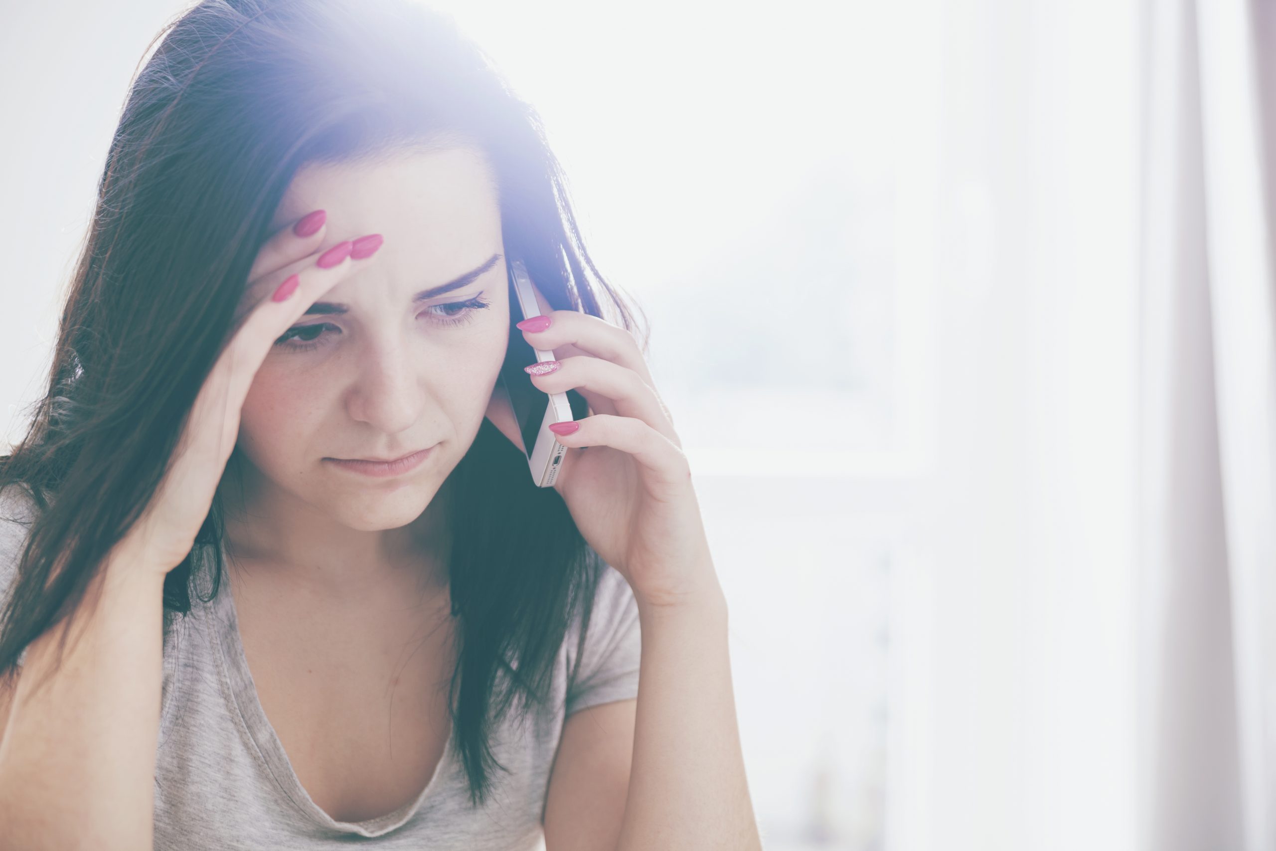 Unhappy worried woman talking on phone at home image of unhappy person on phone demonstrating how iumportant it is to foster Client loyalty and customer love